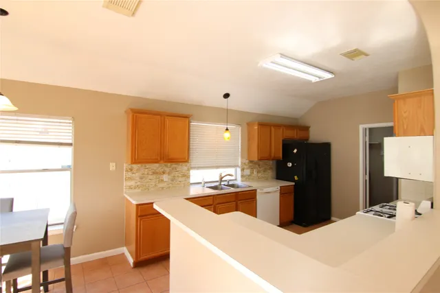 a kitchen with stainless steel appliances kitchen island granite countertop a refrigerator and a stove top oven