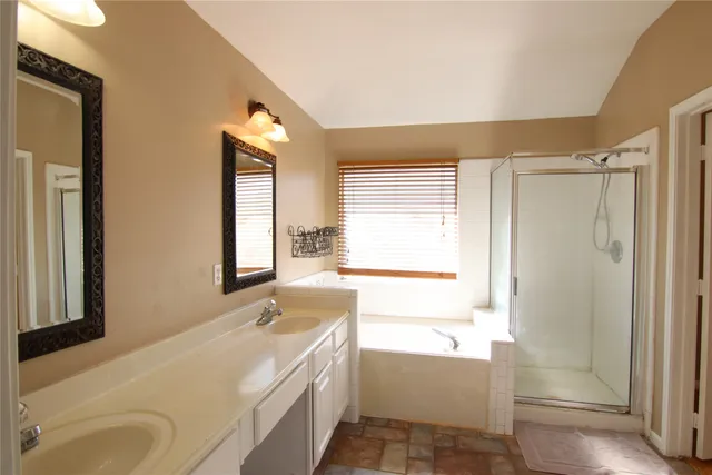 a bathroom with a tub sink and mirror