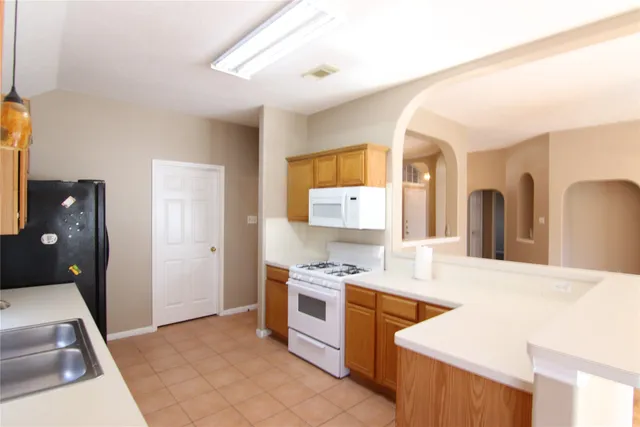 a kitchen with a stove a sink and a refrigerator