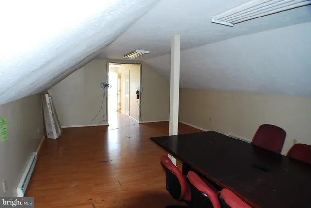 a view of a livingroom with wooden floor and a floor to ceiling window