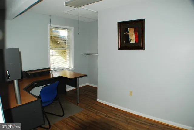 a view of a workspace room with furniture and wooden floor