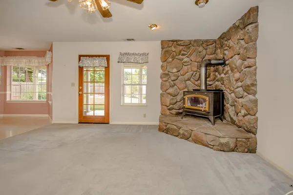 an empty room with windows and a fireplace