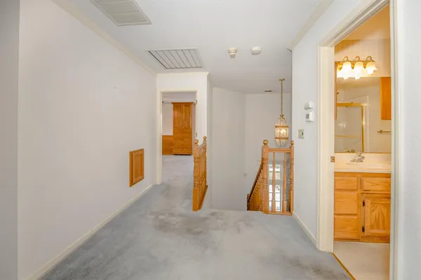 a view of a hallway with wooden floor and a living room