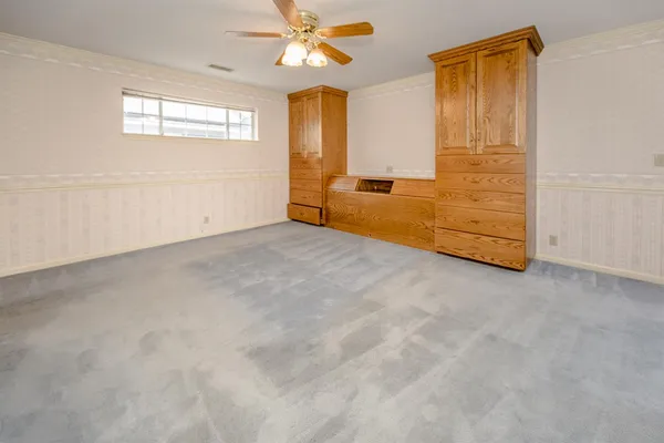 en empty room with windows and ceiling fan
