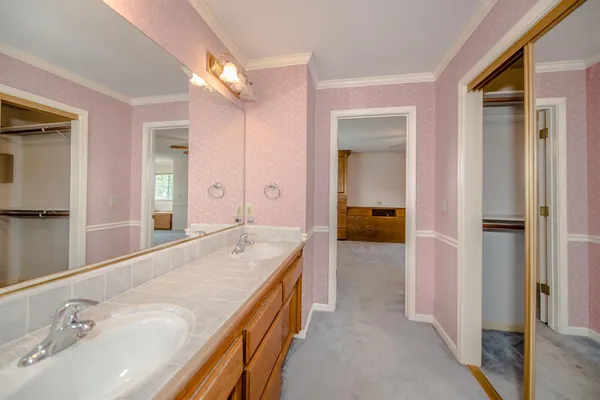 a en suite bathroom with a granite countertop sink and a mirror