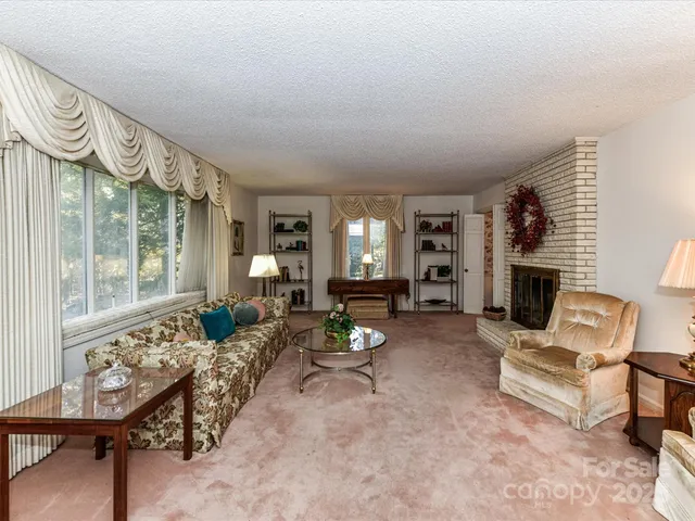 a living room with furniture large window and fireplace