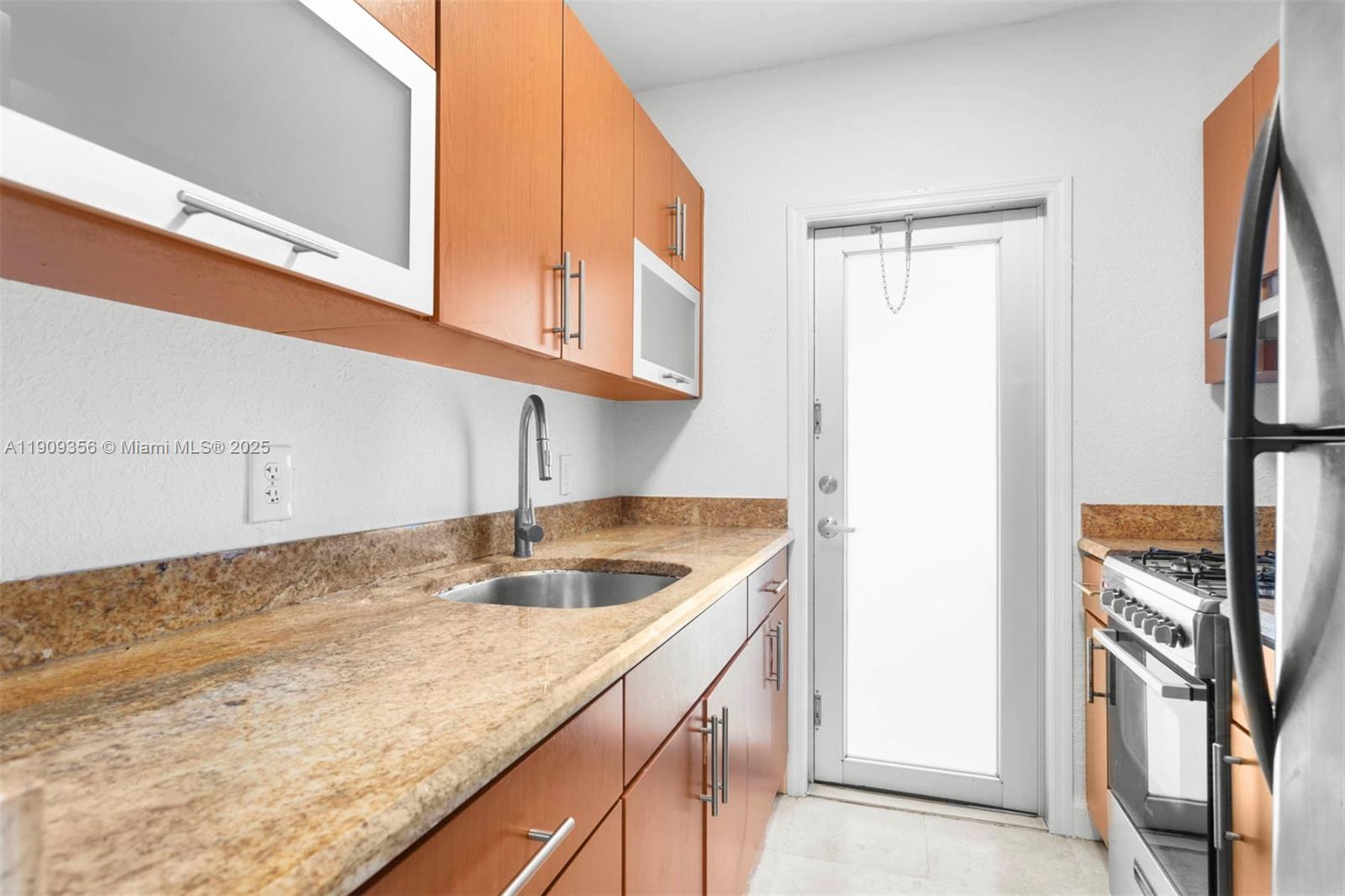 1010 Pennsylvania Avenue, Unit 14 Miami Beach, FL 33139 - Photo 2 of 8 a kitchen with a sink and a refrigerator