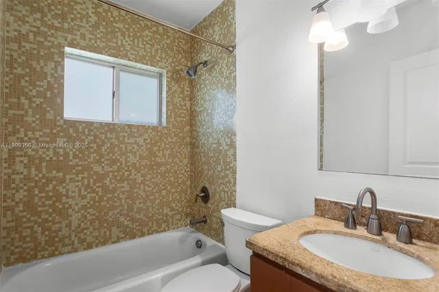 a bathroom with a granite countertop sink a toilet and shower