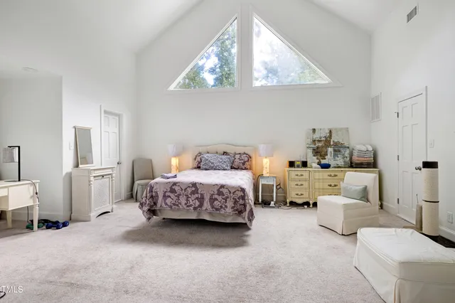 a spacious bedroom with a bed a couch and dresser