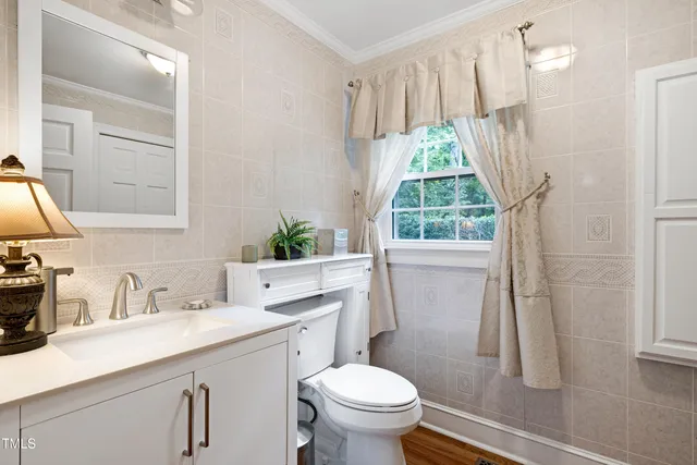 a bathroom with a sink a toilet and a window
