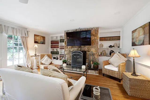 a living room with furniture a flat screen tv and a fireplace
