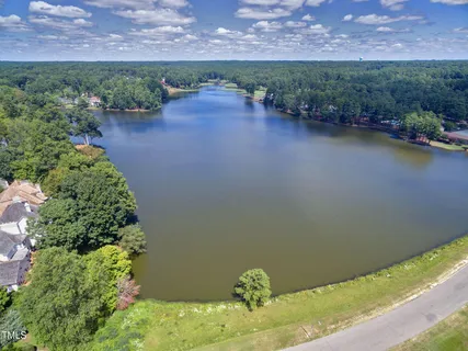 an aerial view of a house with a yard and lake view