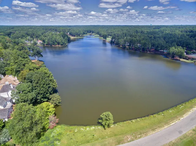 an aerial view of a house with a yard and lake view