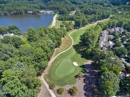 an aerial view of a house with a yard and lake view