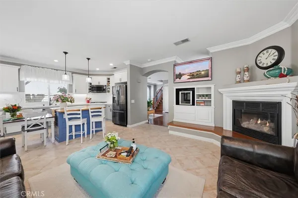 a living room with furniture a fireplace and kitchen view