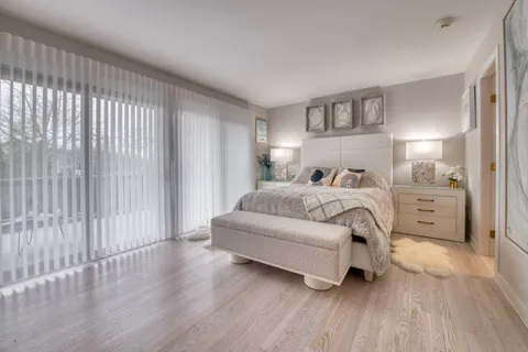 a bedroom with a bed lamp and a large window