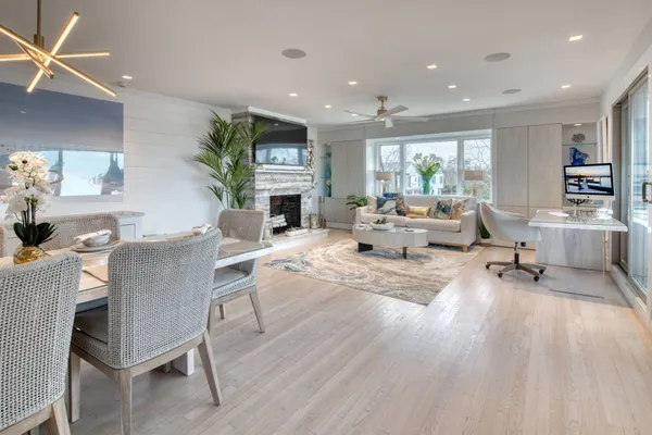 a living room with furniture a fireplace and a dining table with wooden floor