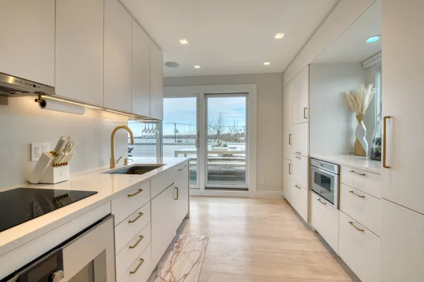 a large white kitchen with a large window