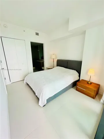 a bedroom with a bed and a night stand