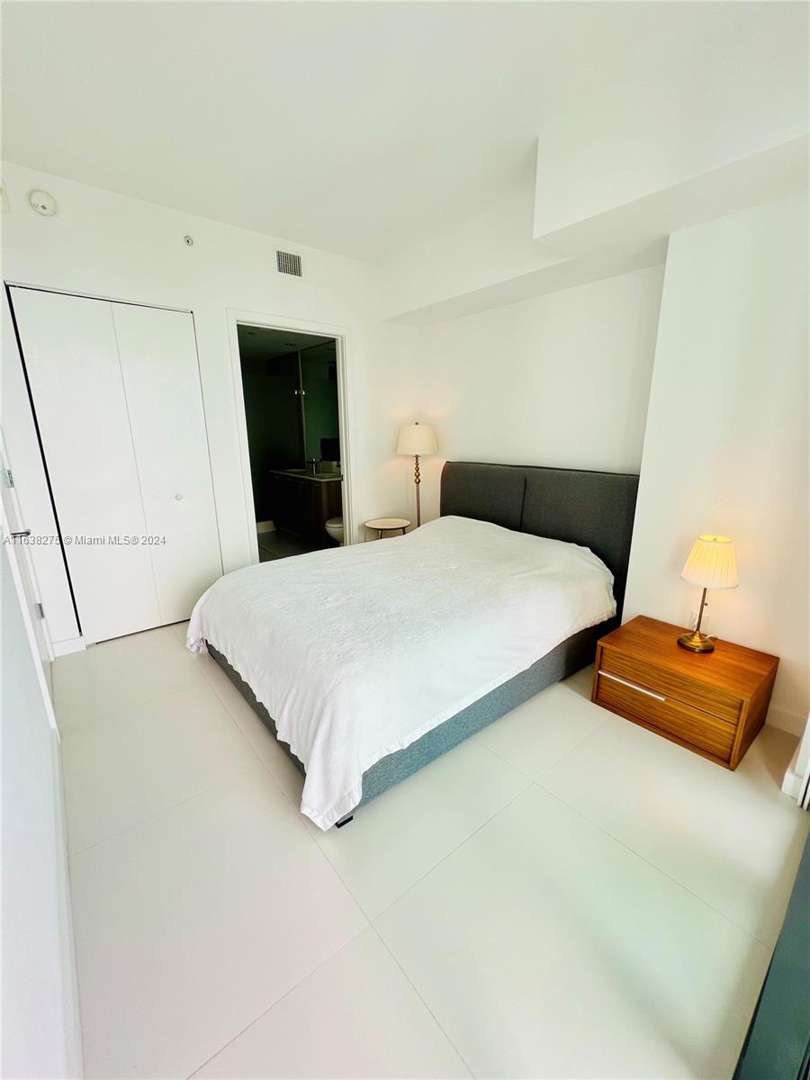 501 Northeast 31st Street, Unit 2204 Miami, FL 33137 - Photo 8 of 26 a bedroom with a bed and a night stand