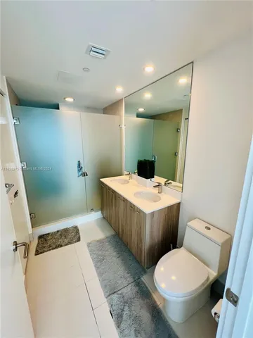 a bathroom with a granite countertop toilet sink and mirror