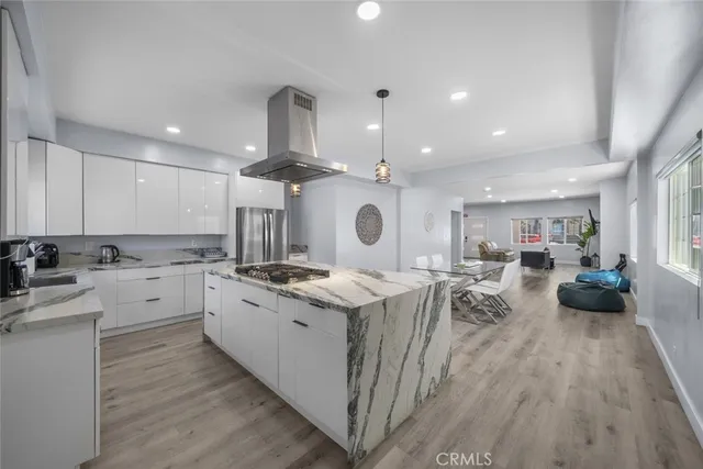 a kitchen with stainless steel appliances granite countertop a lot of counter space and wooden floors