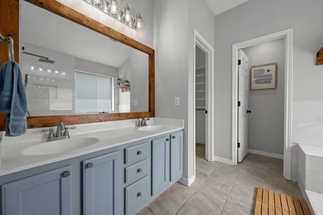 a spacious bathroom with a double vanity sink and a mirror
