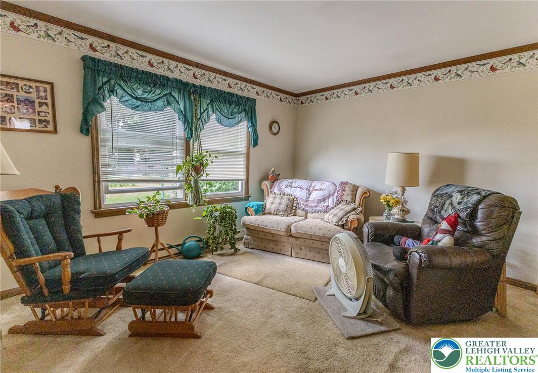 40 Locke Heights Road Bangor, PA 18013 - Photo 17 of 28 A comforting living space features soft carpeting, a decorative wall border, and inviting natural light.