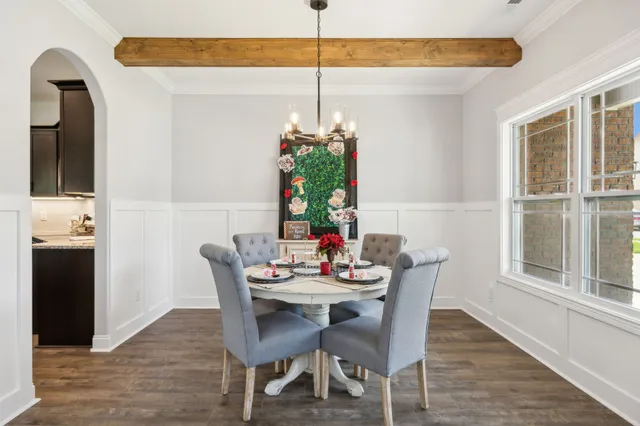 a dining room with furniture a chandelier and window