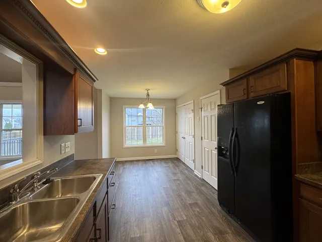 a kitchen with a sink a refrigerator and wooden floor