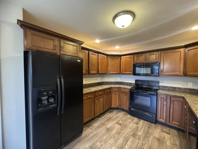 a kitchen with stainless steel appliances granite countertop a refrigerator stove and oven