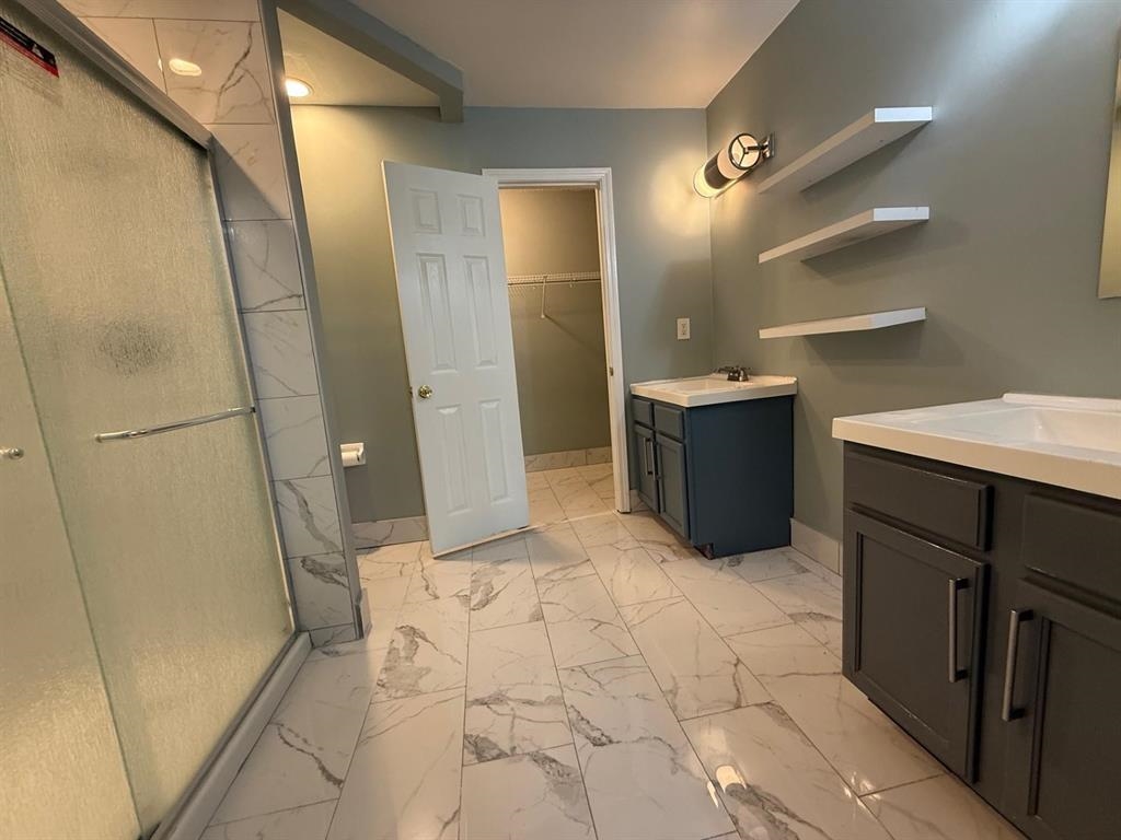 1173 Island Place East Memphis, TN 38103 - Photo 12 of 18 Bathroom with two vanities, light marble finish flooring, a shower stall, and a walk in closet