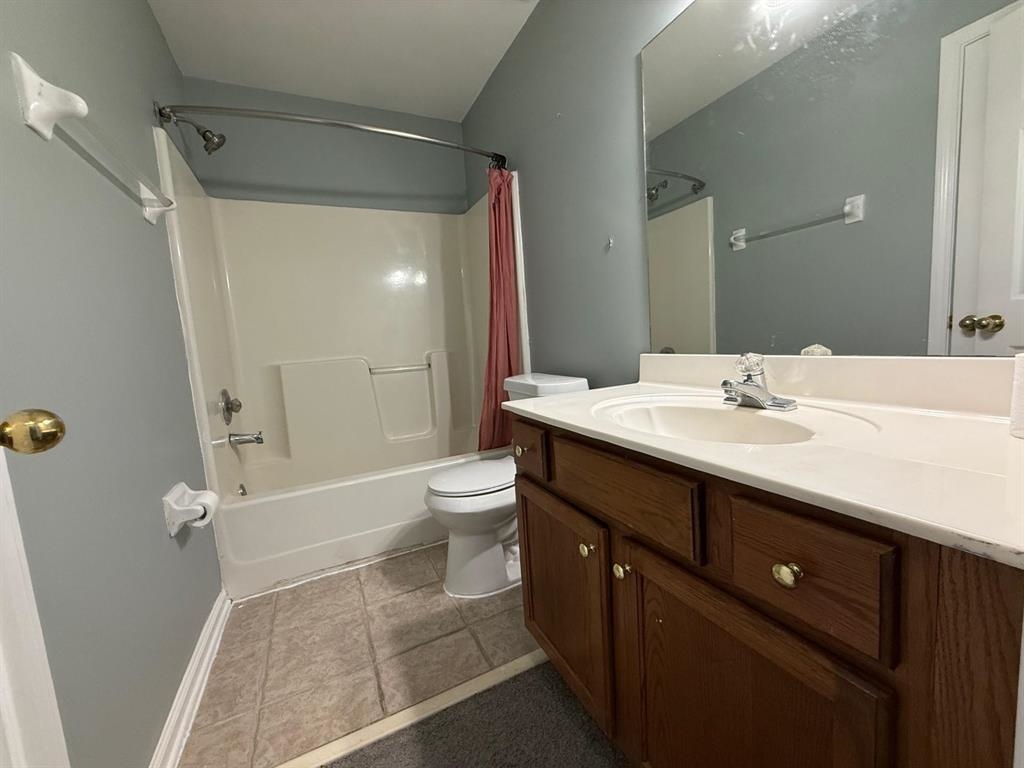 1173 Island Place East Memphis, TN 38103 - Photo 14 of 18 Bathroom with vanity, shower / bath combo with shower curtain, and dark tile patterned floors