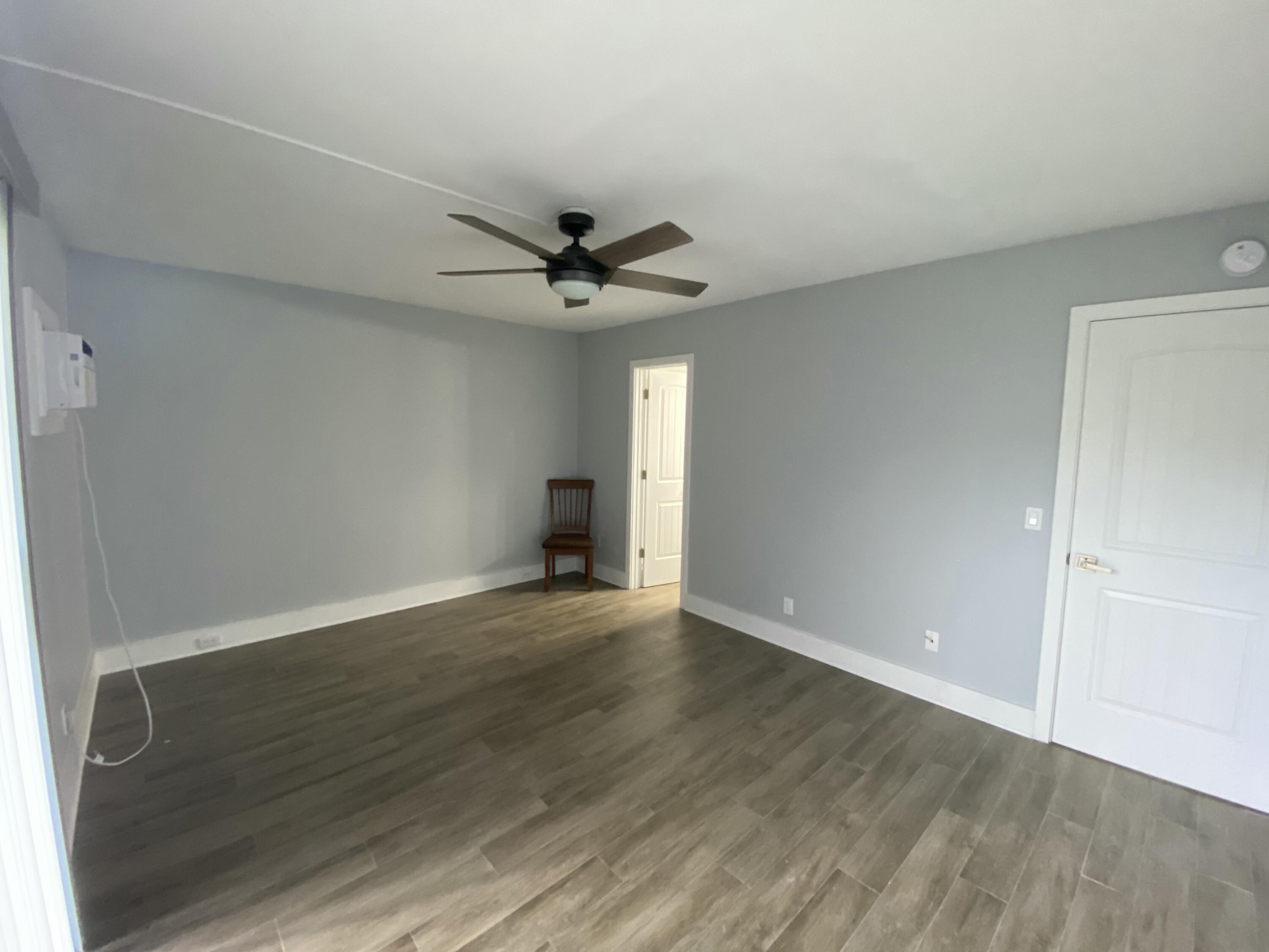 342 Mansfield Drive, Unit I Boca Raton, FL 33434 - Photo 7 of 17 an empty room with wooden floor and a ceiling fan