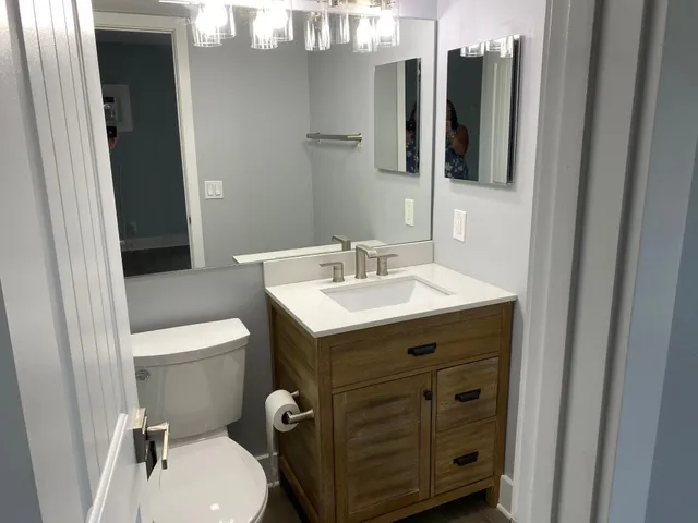 a bathroom with a sink mirror vanity and toilet