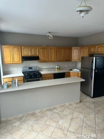 a kitchen with stainless steel appliances a refrigerator a sink a stove a microwave a counter top and cabinets