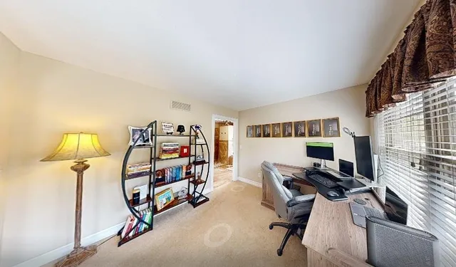 a view of a workspace with furniture and a window
