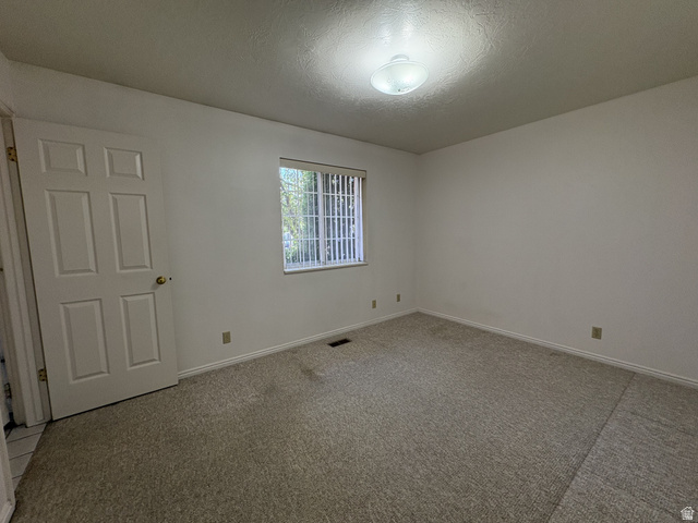 486 West 120 North Orem, UT 84057 - Photo 14 of 30 Carpeted room featuring a white paneled door, a single window with vertical blinds, and a flush-mount ceiling light