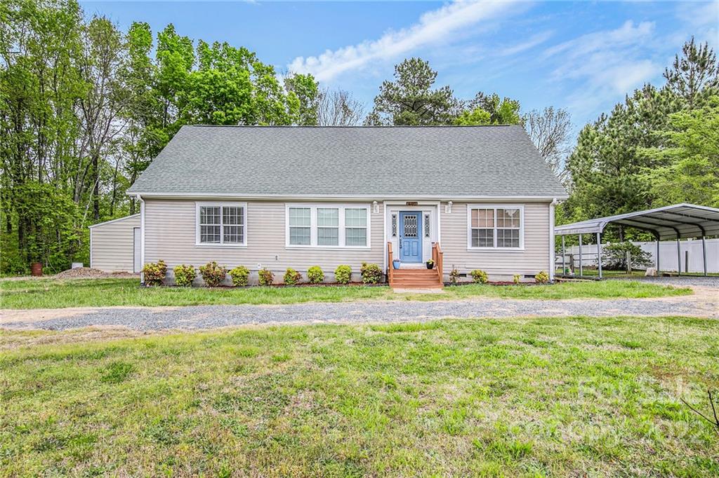 a view of a house with a yard and trees