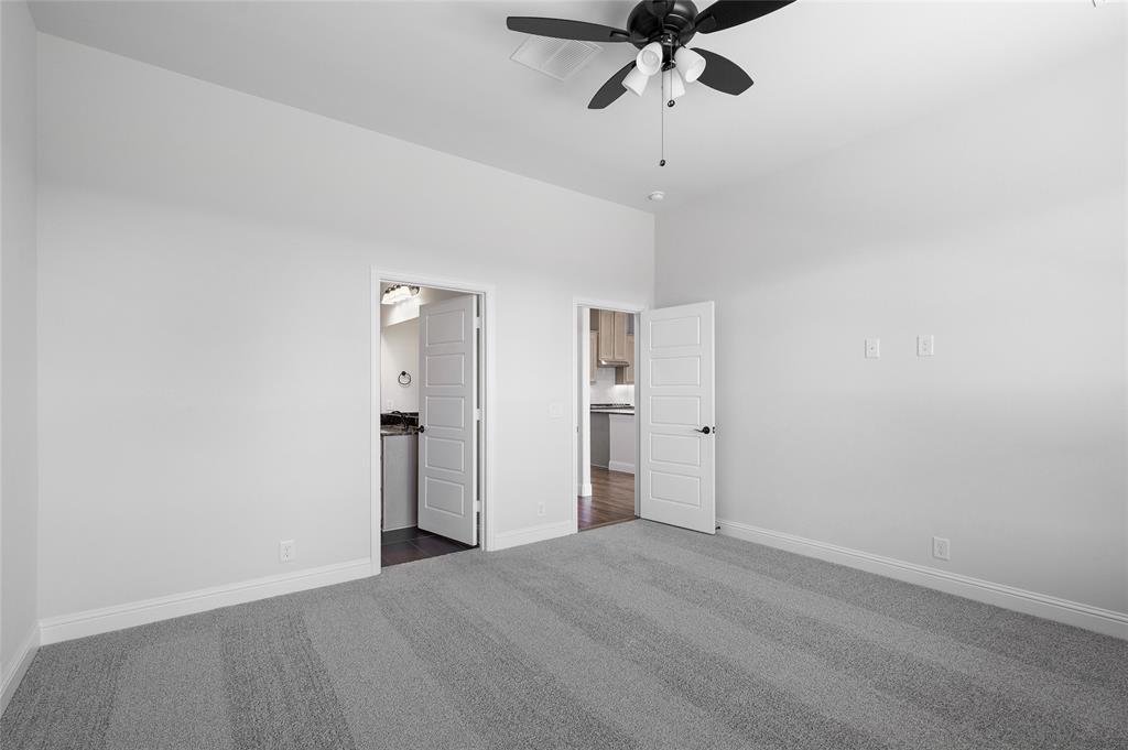 613 Brazos Drive Van Alstyne, TX 75495 - Photo 16 of 29 Unfurnished bedroom featuring dark colored carpet, connected bathroom, and a ceiling fan