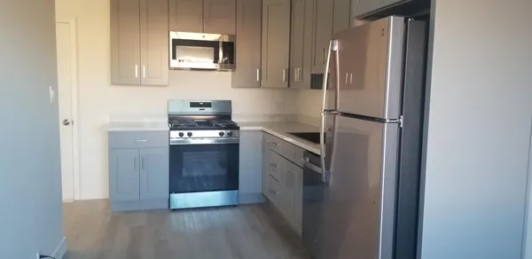 a kitchen with a refrigerator and a stove top oven