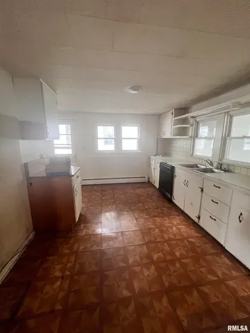 a large white kitchen with cabinets and a window