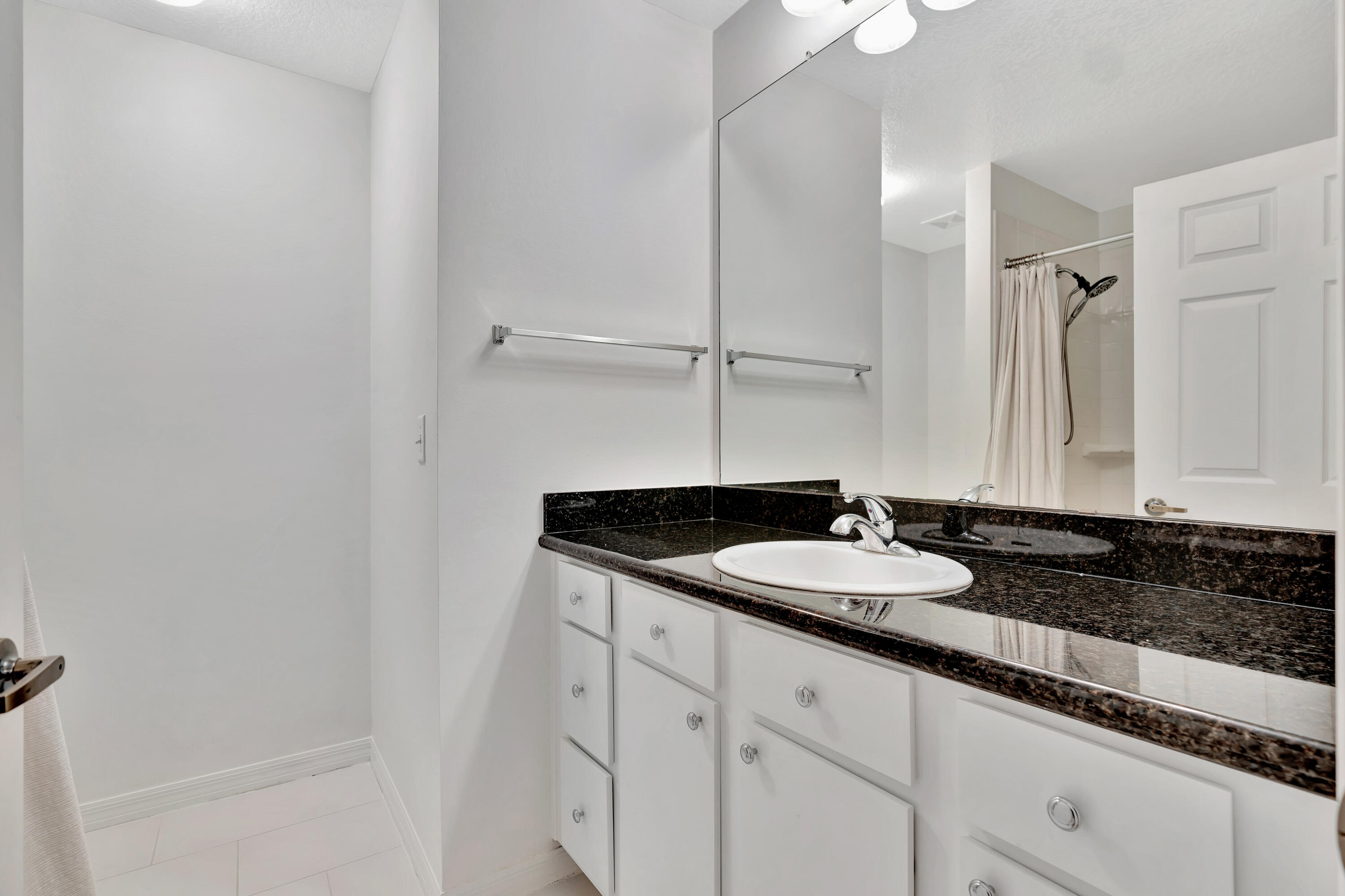 1561 Southeast Pomeroy Street Stuart, FL 34997 - Photo 16 of 25 a bathroom with a granite countertop sink and a mirror