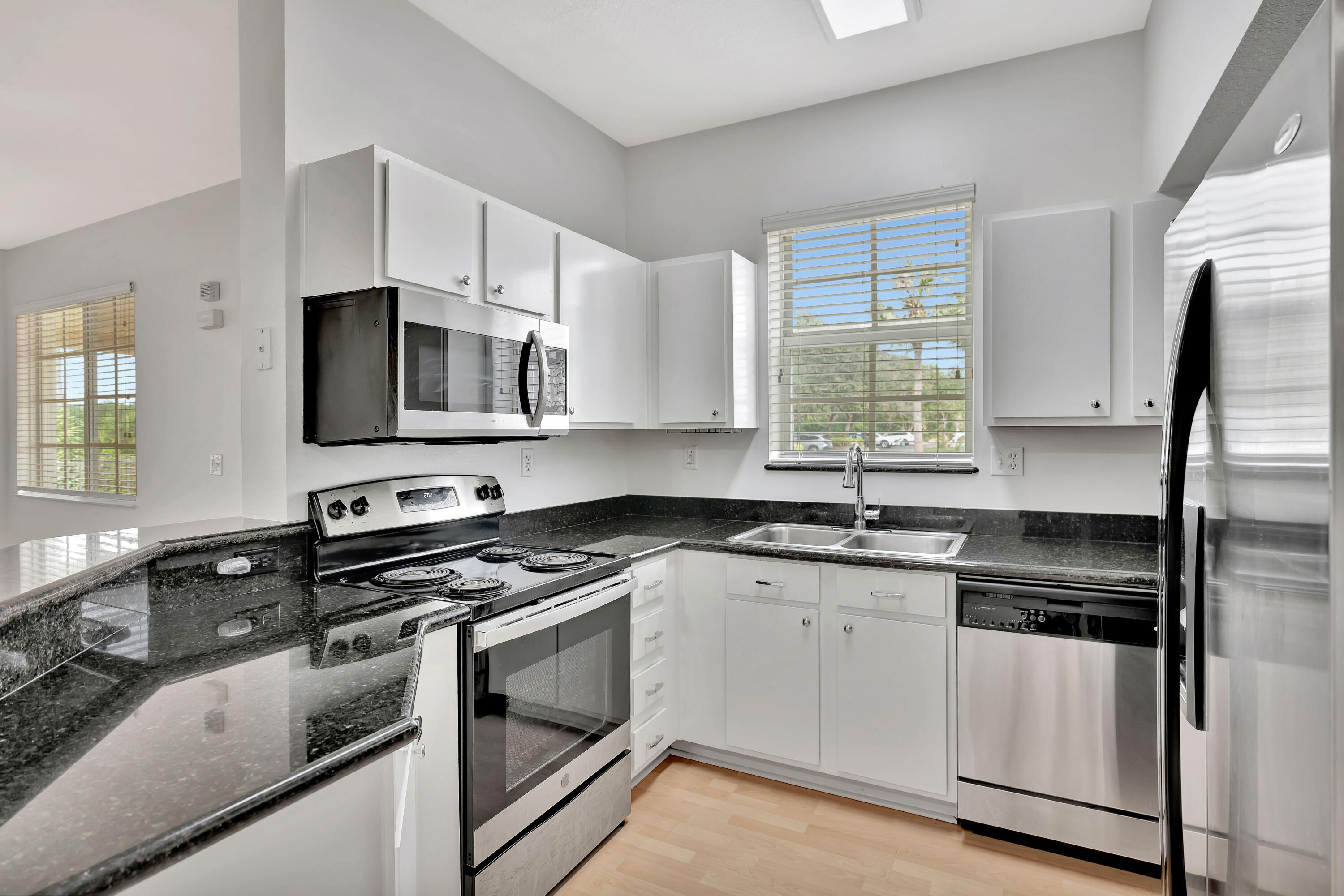1561 Southeast Pomeroy Street Stuart, FL 34997 - Photo 9 of 25 a kitchen with granite countertop a sink cabinets stainless steel appliances and a window