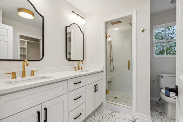 a bathroom with a double vanity sink mirror and shower
