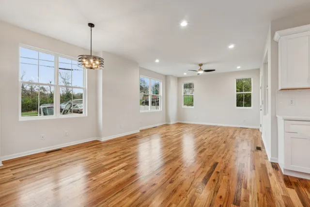 a view of an empty room with window and wooden floor