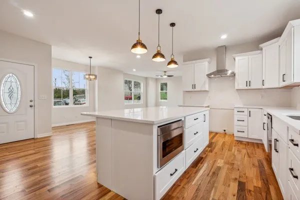 a kitchen with stainless steel appliances granite countertop a stove and a wooden floors