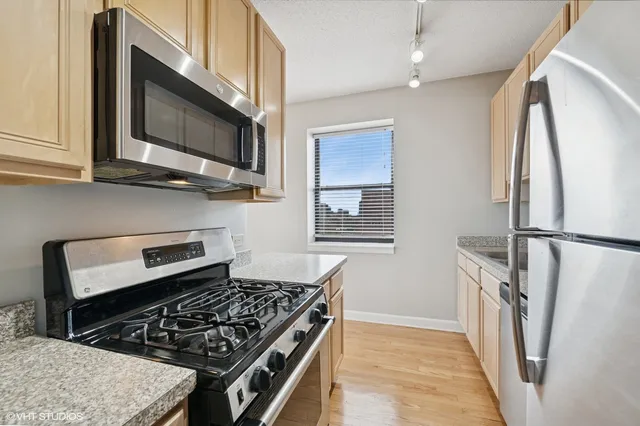 a kitchen with stainless steel appliances granite countertop a stove microwave and refrigerator