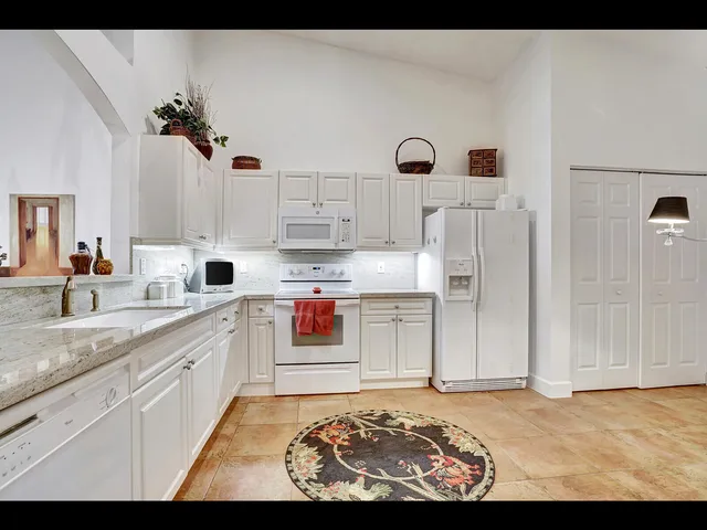 a kitchen with white cabinets and sink