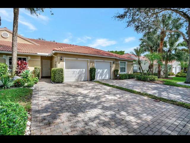 a view of white house with a yard and potted plants